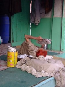 Henna dyed man reading a paper in Pakistan