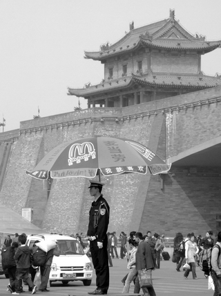 Chinese Policeman under a McDonald's umbrella directing traffic in China