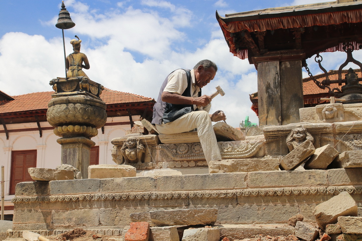 Stone mason working on restoring the Vatsala Durga temple in Bhaktapur Nepal