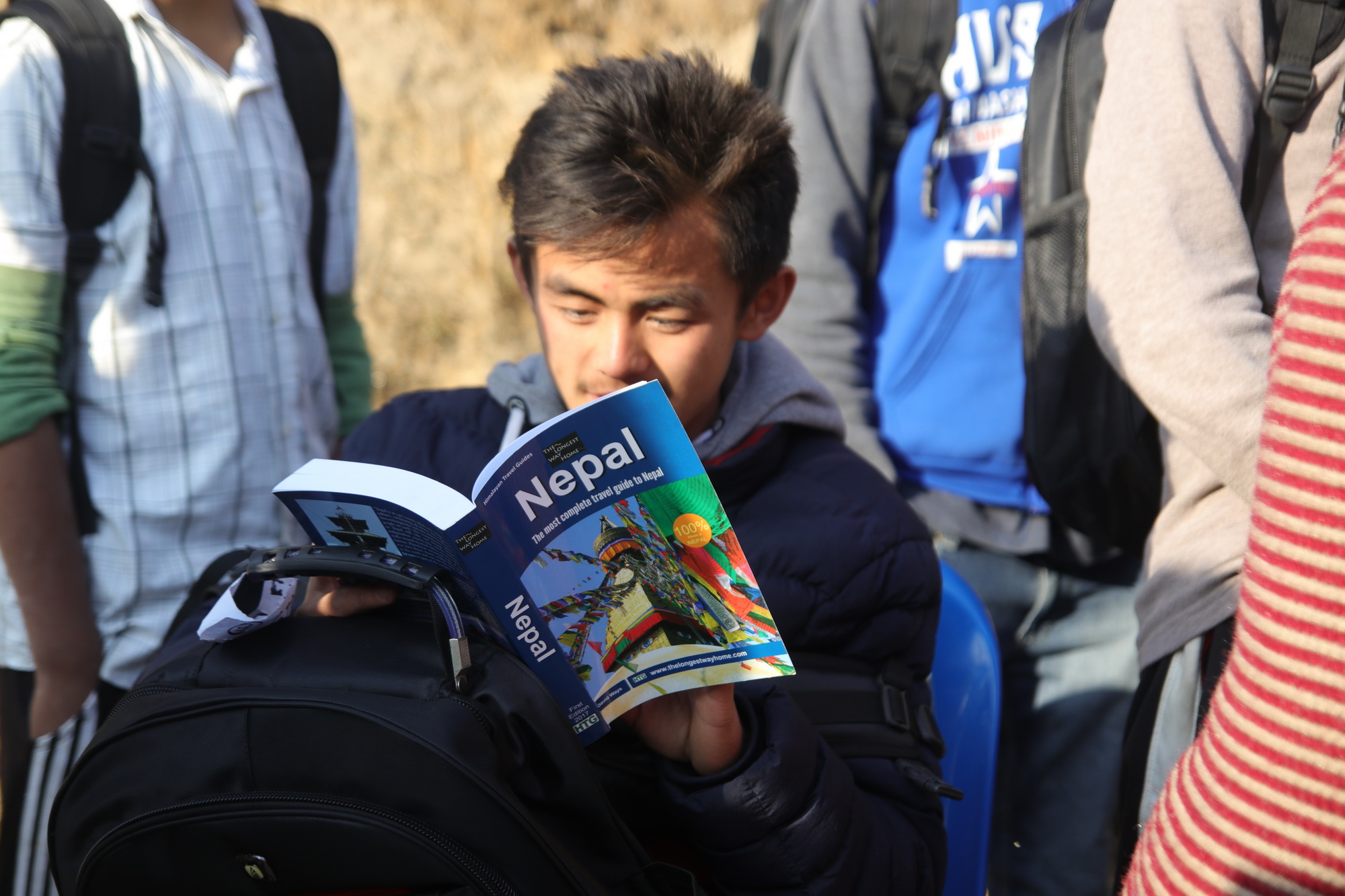 Boy reading from a Nepal guidebook