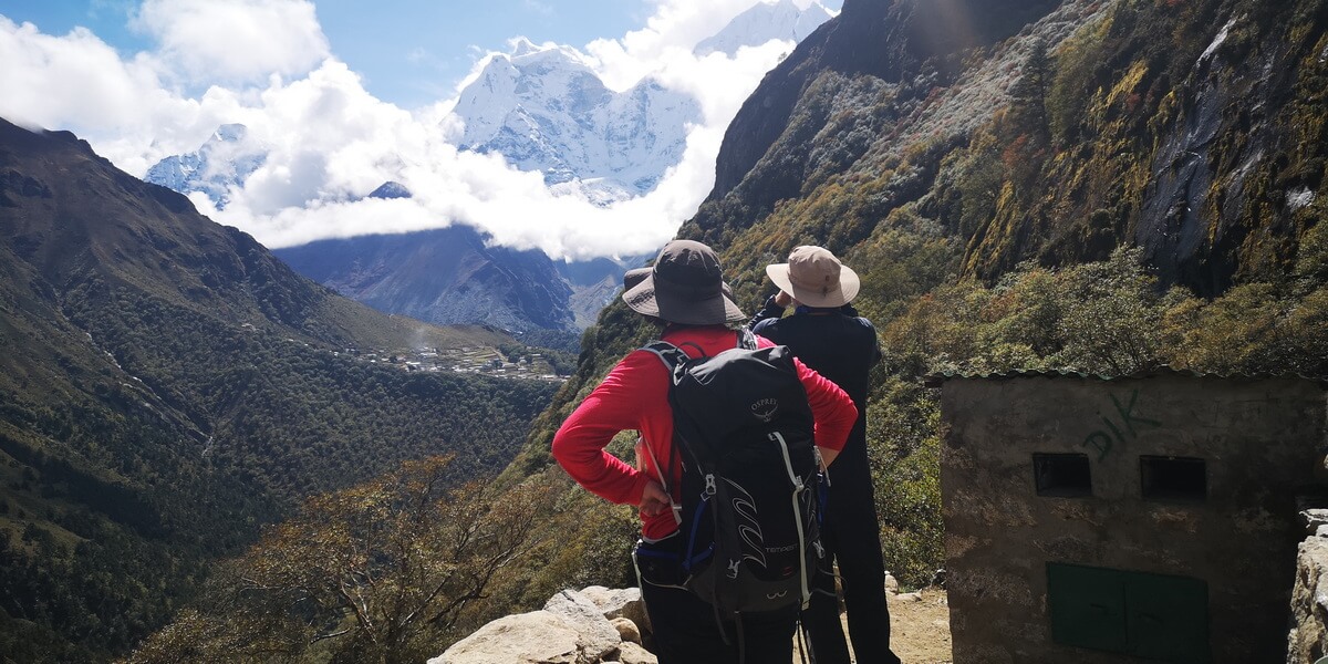 Trekker and guide in Nepal looking at a mountain