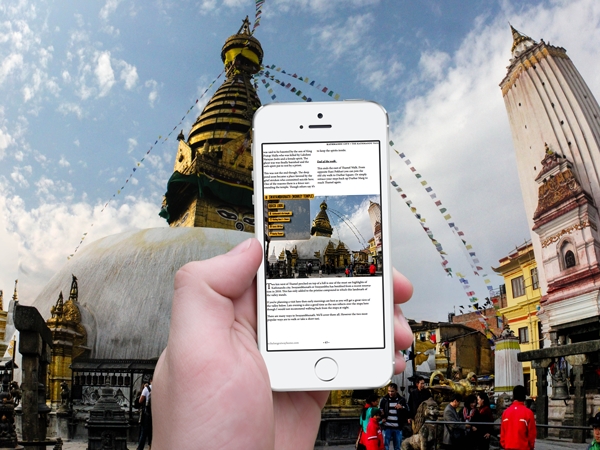 Nepal guidebook on mobile in front of stupa in Nepal